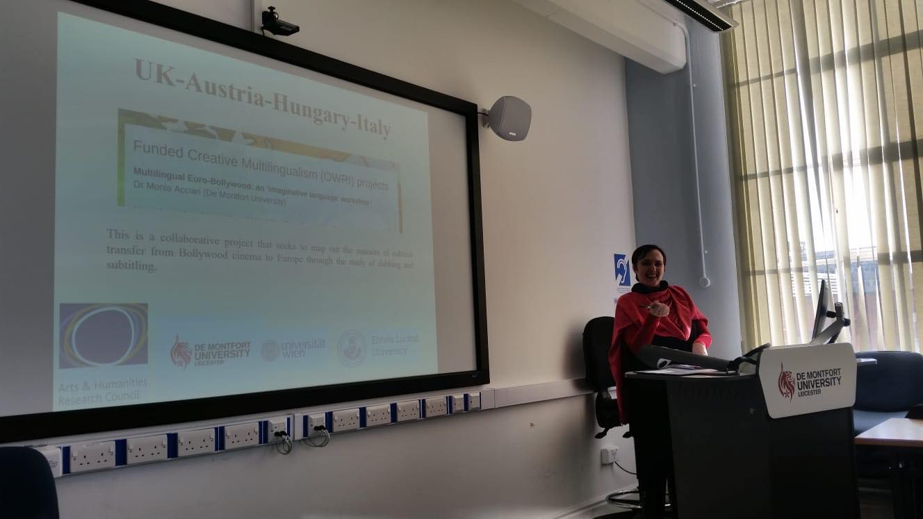 Presenter giving an audio-visual presentation behind a lectern.