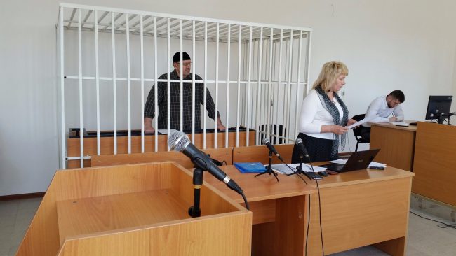 Man behind bars in a courtroom