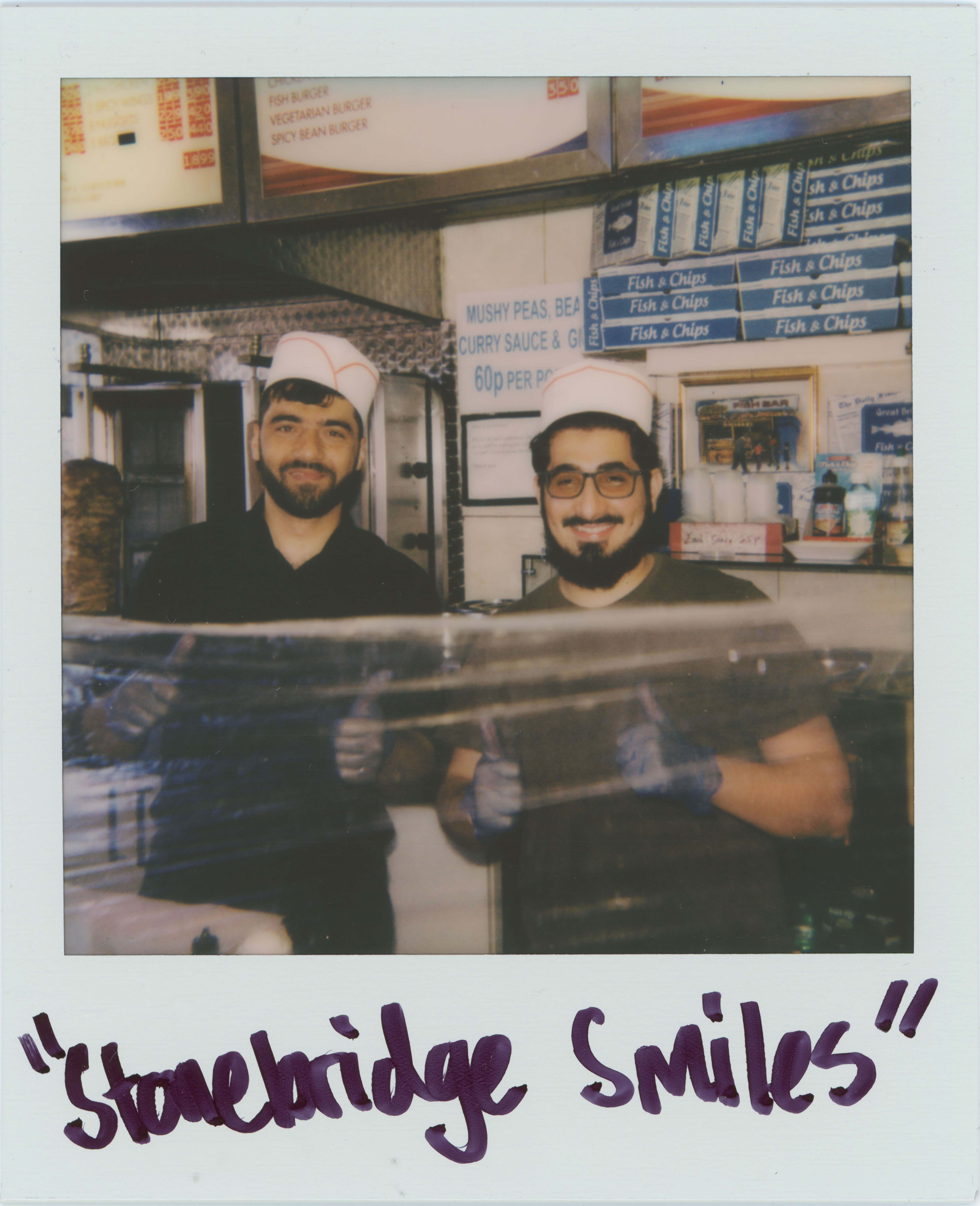 two men behind food counter