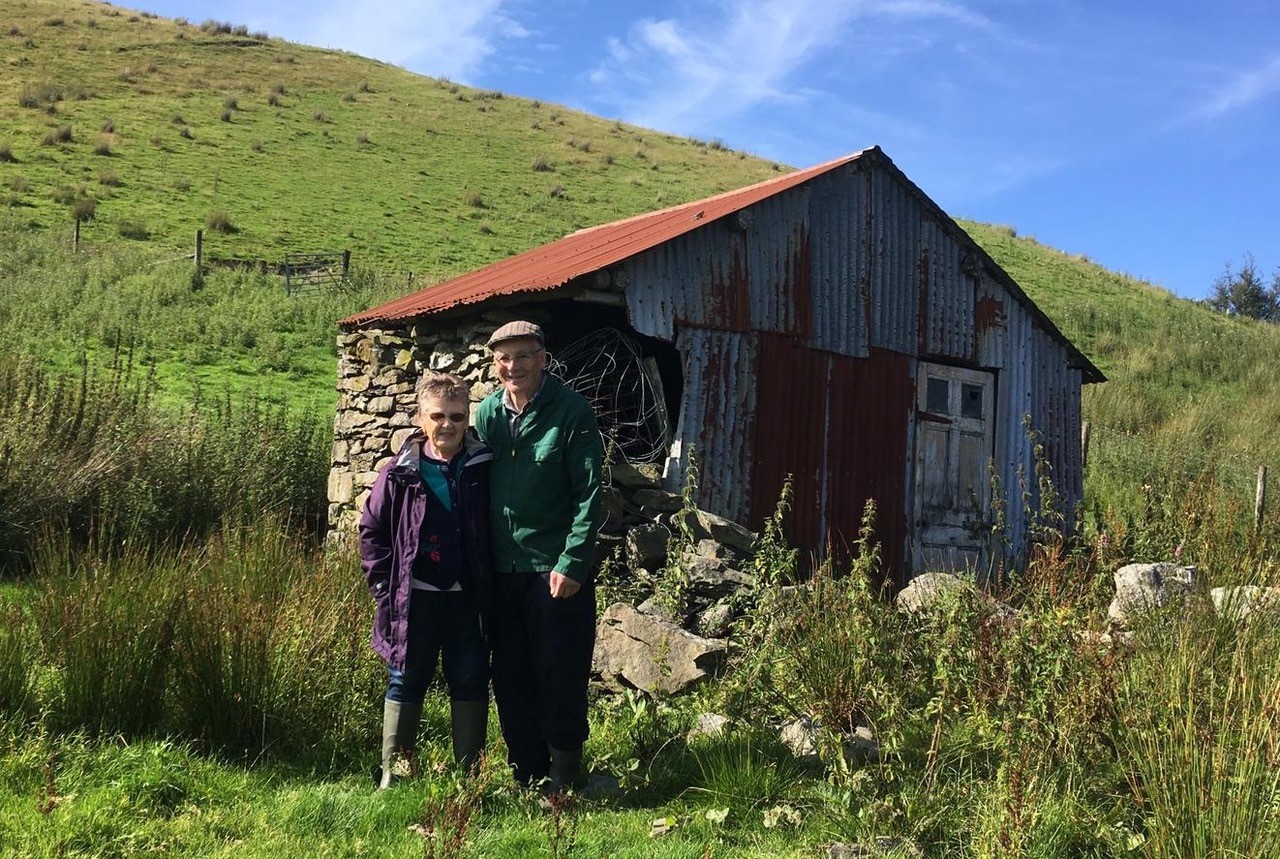 man and woman before a hut