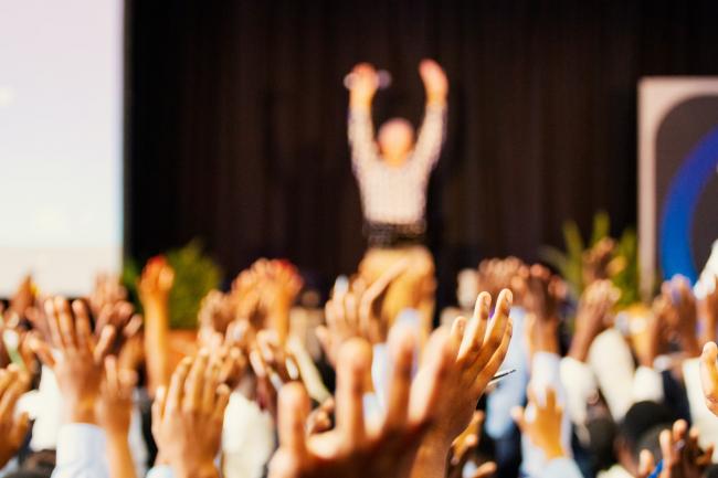 Raised hands in an auditorium